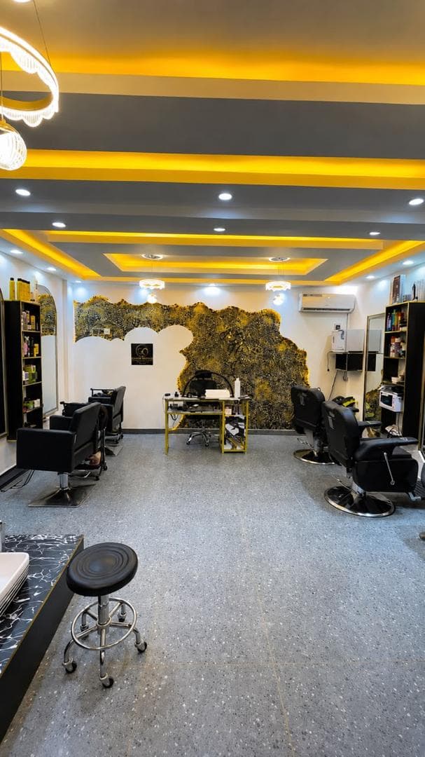 L'espace coiffure de Nova House : fauteuils barbier de part et d'autre et mur signature noir et or